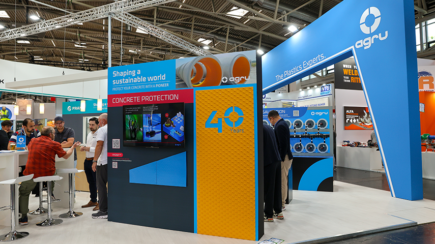 Messestand mit Beschriftung zur Betonschutzlösung, Monitor mit Visualisierung und markanter Jubiläumsanzeige