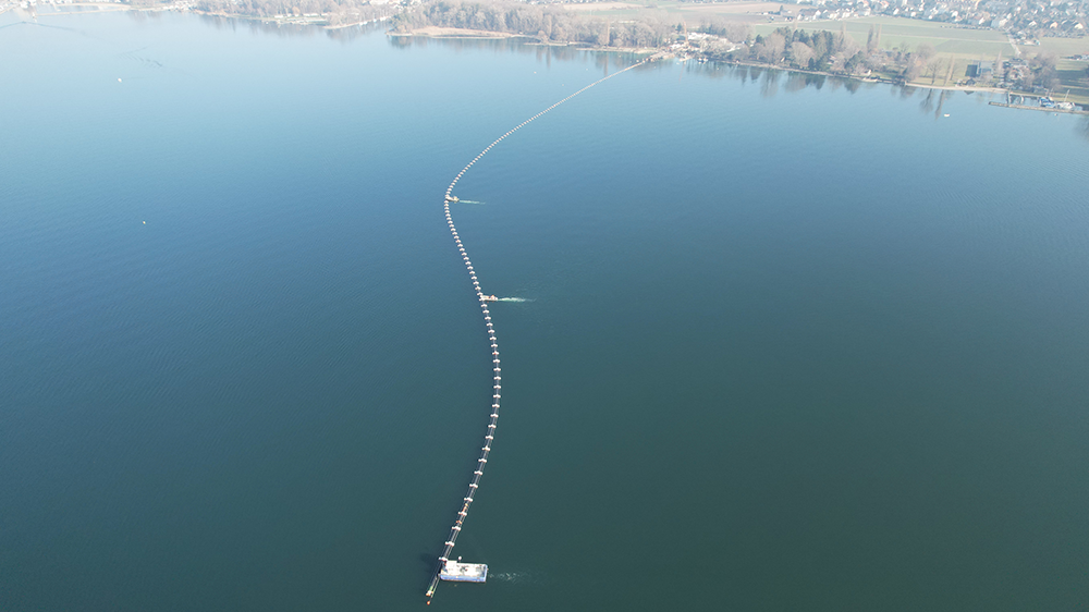 Der 750 Meter lange Leitungsstrang wird kontrolliert positioniert und abgesenkt. Foto: Hydrokarst Swiss SA